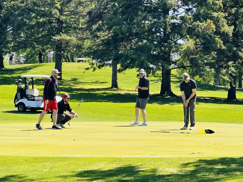 Team reading a putt on the green