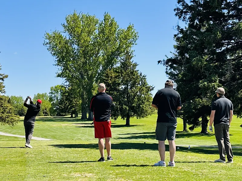 Team watching a tee shot from the fairway